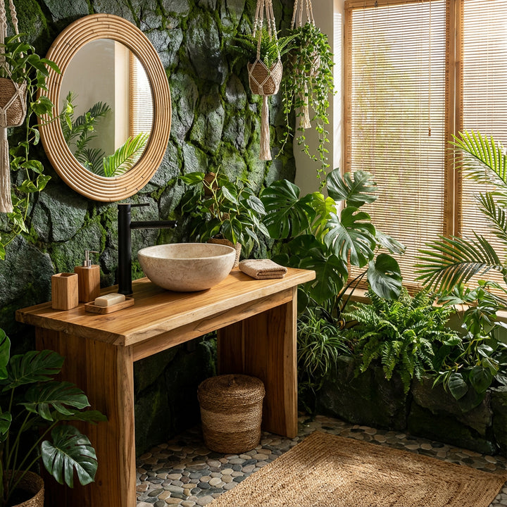 Round countertop washbasin made of light stone on a wooden washbasin with black fittings in a green spa bathroom ambience