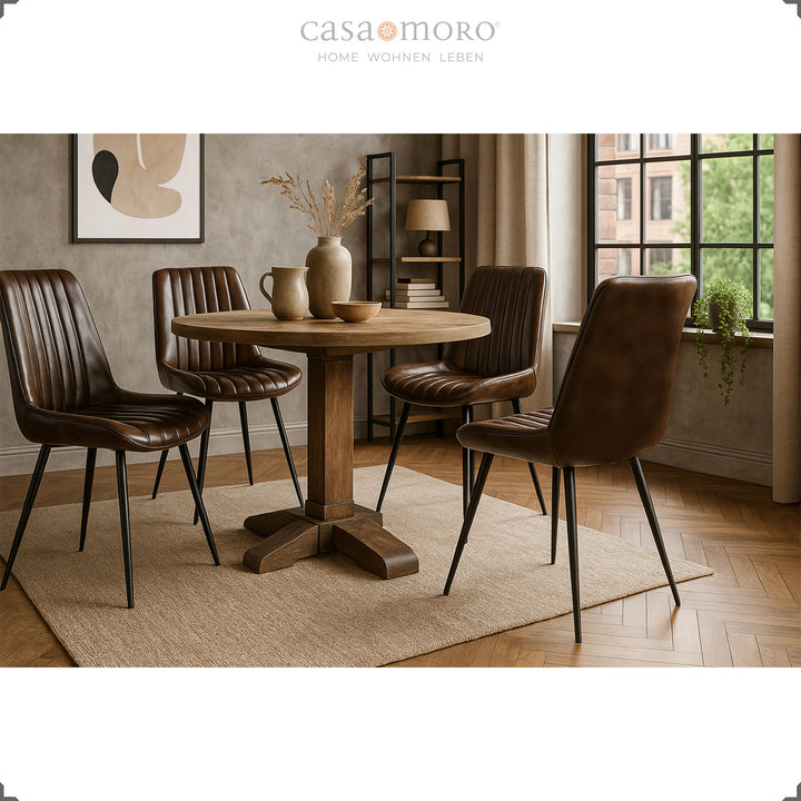 Four antique brown genuine leather dining chairs around a round wooden table, stylish living room in warm light