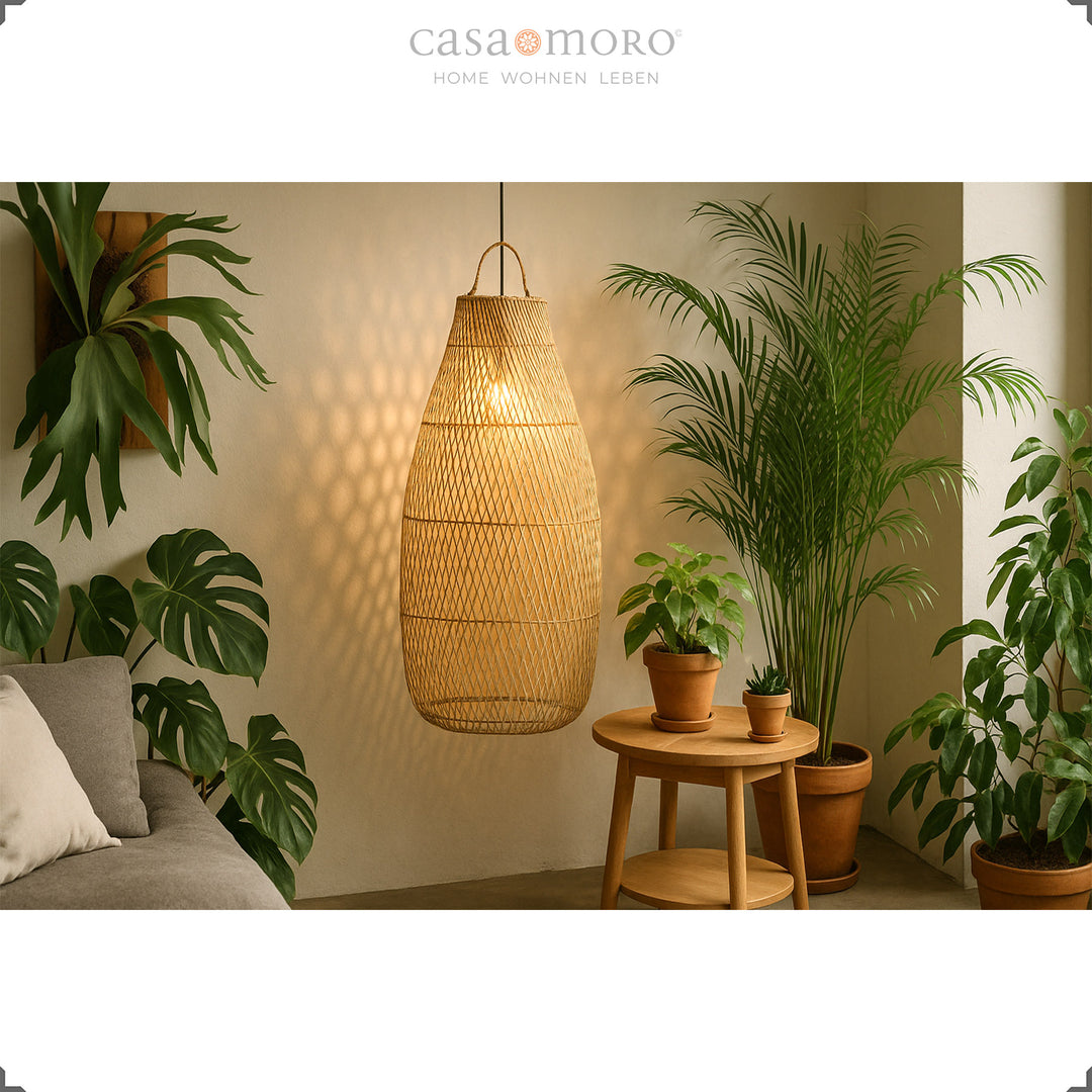 Tall, hanging rattan lamp in the living room with lots of green plants and soft light
