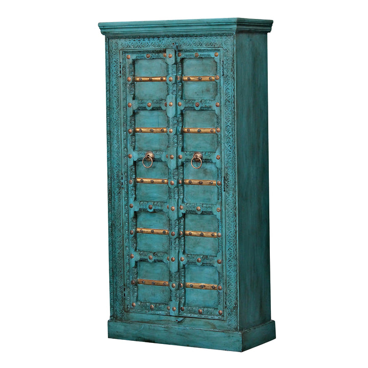 Turquoise solid mango wood storage cabinet with two ornate doors and ring handles, viewed from an angle.