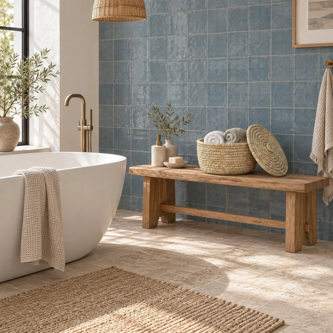 A palm-leaf storage basket with a 15-liter capacity, containing towels and featuring a lid resting against it, sitting on a wooden bench in the bathroom.