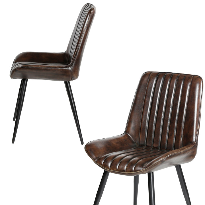 Antique brown leather chairs with vertical quilting, photographed sideways and diagonally, on black painted metal legs