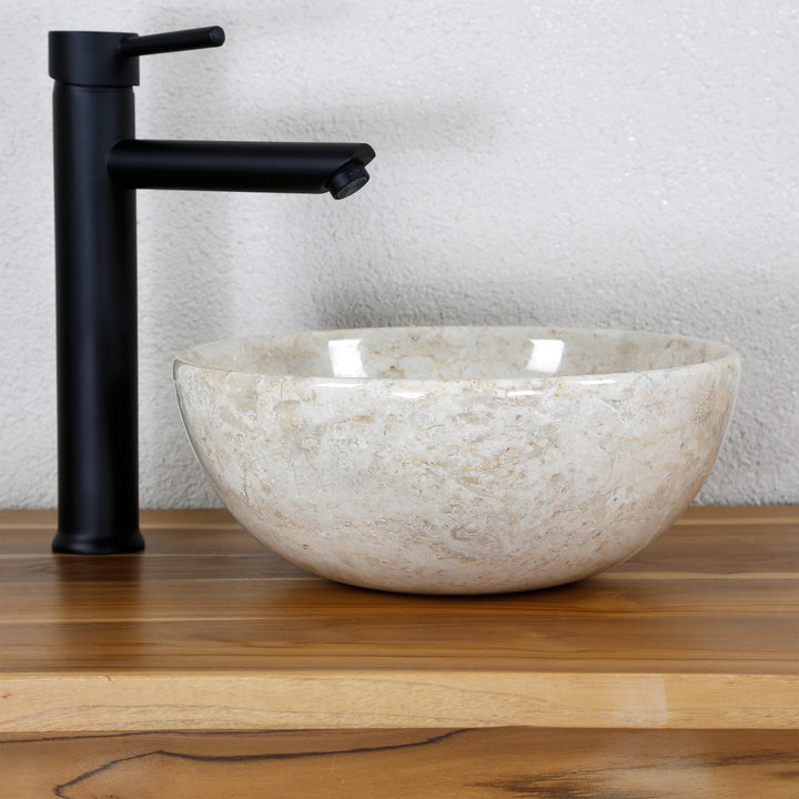 Bright marble countertop washbasin on a wooden top with a black fitting in a clear, minimalist studio setting