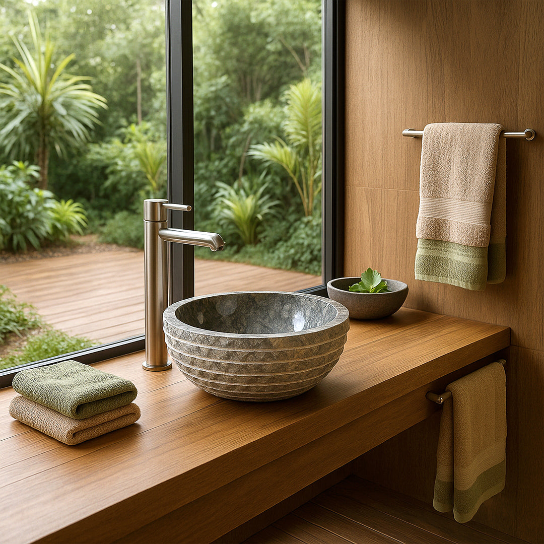 Round countertop stone sink on vanity unit, modern bathroom with window view of greenery, towels and plant