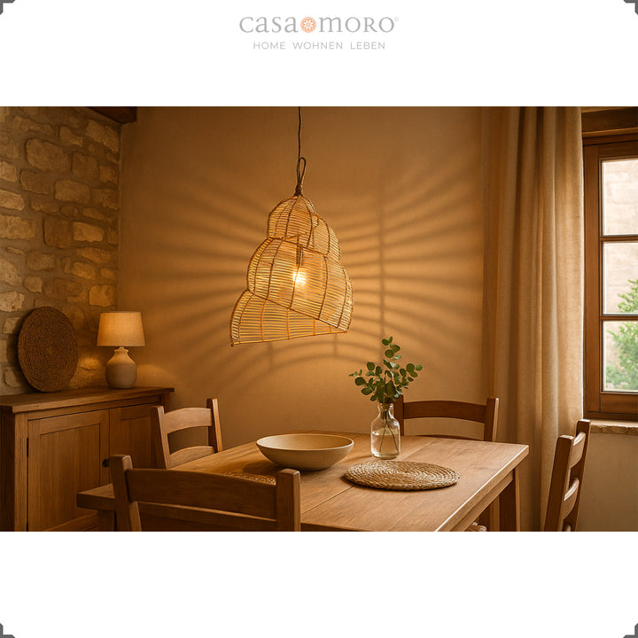 Handmade rattan lamp above a wooden table in the dining room, creates warm light and natural atmosphere
