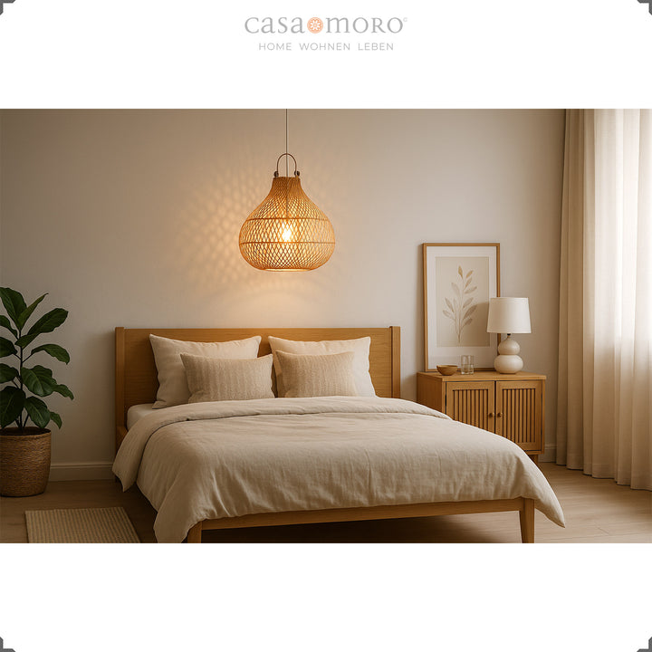 Natural rattan lamp above bed in bedroom with warm light and bright furnishings
