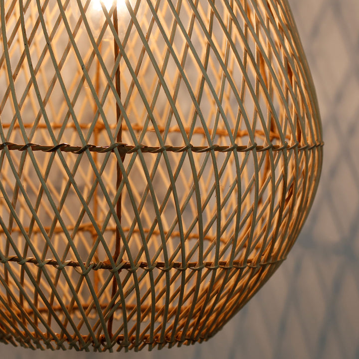 Detailed shot of a handmade rattan lamp with a fine, diagonal weave pattern and warm light
