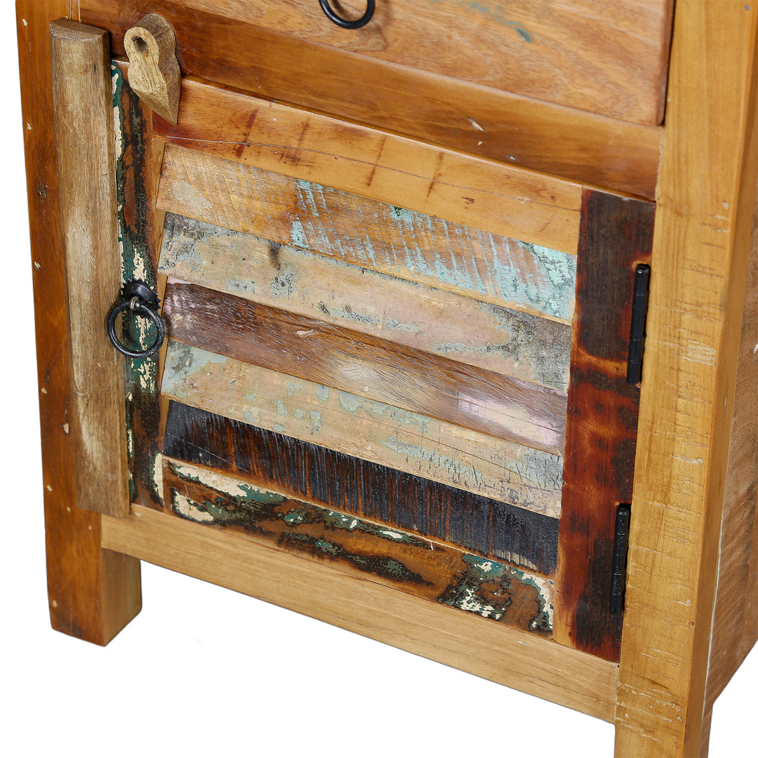 Detailed view of the door of a chest of drawers made of solid wood with a patchwork front and metal fittings