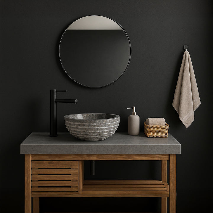 Gray stone washbasin as a countertop basin on the vanity unit, modern bathroom with dark walls, mirror and black fittings