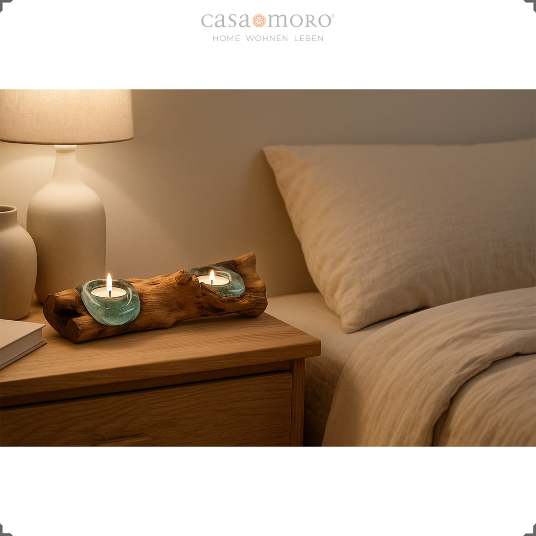 Elongated tea light holder made of glass and burl wood on a bedside table, its soft light creates a calming bedroom atmosphere.