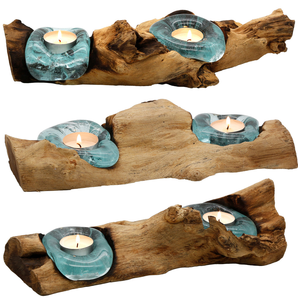 Elongated tea light holders made of glass and root wood in three versions, each with its own shape and warmly glowing tea light