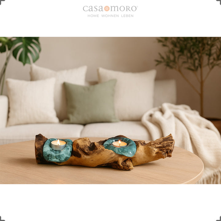 2 tea light holders made of glass and burl wood on a round table, its soft light complements the bright, cozy living room.