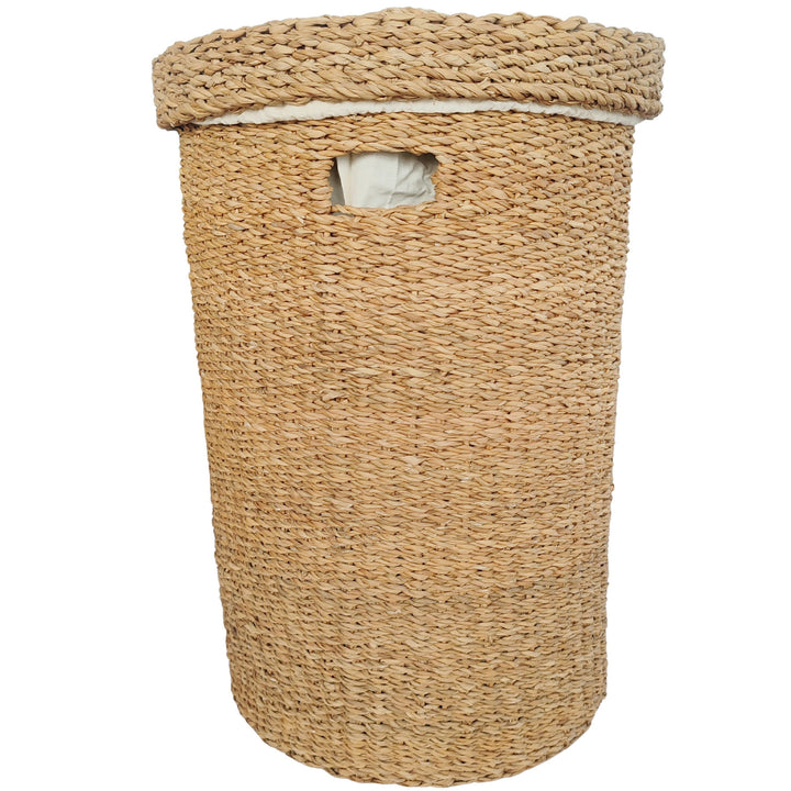 Round laundry basket made of seagrass with a 75-liter capacity, a closed lid, a handle opening, and a light-colored fabric insert.